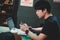 Selective focus young smart asian man wore black t shirt, working with laptop in coffee shop