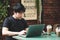 Selective focus young smart asian man wore black t shirt, working with laptop in coffee shop
