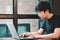 Selective focus young smart asian man wore black t shirt, working with laptop in coffee shop