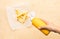 Selective focus of youngwoman squeezing a bottle sauce  mustard  for dipping with french fried on wood table background