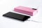 Selective soft focus photo of charging smart phone via pink color power bank