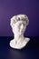 Selectve focus of bust of david replica on a purple background