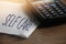 Self care words on napkin and calculator on wooden table. Healthcare concept