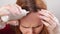 self-coloring the gray roots of hair on the head of a woman.