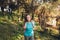 Self-confidence. Teenage girl looking at camera carrying backpack with serene smile in forest.