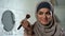 Self-confident arab lady doing make-up, applying powder by brush, femininity