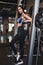 Self confident sportswoman with slim figure posing in gym