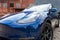Self driving Tesla Model Y Exterior. Blue metallic, black titanium rims, panoramic sunroof, led headlights