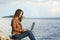 Self employed woman working with a laptop on the beach