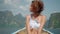 self enjoying woman in white swimsuit, travels on the boat at national park
