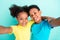 Self-portrait of attractive cheerful schoolkids hugging best fellow  over bright teal turquoise color background