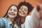 Self-portrait of two happy joyful teen girls of different races making selfie, enjoying friendship