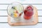Self pouring ice tea serve with ice cube with fruits frozen inside on a wooden plate and table