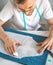 A self-taught seamster in white t-shirt and glasses works with fabric, pattern and chalk. A tailor transfers a template to fabric