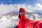 Selfi male mountaineer in snowy mountains, wearing a helmet with a backpack