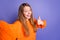 Selfie cadre of smiling happy teenage girl showing like symbol thumb up spend halloween holiday alone isolated on violet