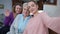 Selfie camera POV of cheerful multigenerational women taking selfie at home indoors. Positive Caucasian adult senior and