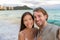 Selfie couple on Waikiki beach taking pictures with smartphone during night out walk on beach summer vacations in