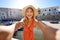 Selfie girl in southern Italy. Young tourist woman taking self portrait with the ancient port of Monopoli, Apulia, Italy