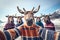 Selfie of group of reindeer wearing warm sweaters and hats on the beach