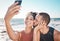 Selfie kiss, love and couple with a phone for streaming, training and care at the beach in Bali. Gratitude, exercise and