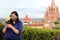 Selfie with mobile phone of Latina tourist woman with protection mask on terrace with cathedral view in San Miguel de Allende, Gu