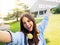 Selfie perspective of young smiling student woman enjoying on campus