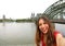 Selfie photo of woman in Cologne with Hohenzollern Bridge and Cathedral on the background, Cologne, Germany. Traveling in Europe.