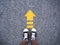 Selfie sneaker black shoes on concrete road with yellow arrow li