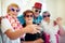 Selfie time guys. Shot of a group carefree elderly people wearing glasses and looking at the camera inside of a building