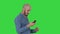 Selfie time! Handsome young man taking selfie with his phone on a green screen, chroma key.