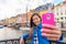 Selfie tourist girl taking photo with phone at Copenhagen Nyhavn, famous Europe tourism attraction. Asian woman visiting the old