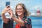 Selfie, travel and woman with phone by harbor enjoying vacation, holiday and journey in Amsterdam. Freedom, adventure