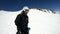 A selfie wide angle male skier aged in black equipment and white helmet rides on a snowy slope on a sunny day. The
