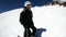 A selfie wide angle male skier aged in black equipment and white helmet rides on a snowy slope on a sunny day. The