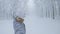 SELFIE: Woman snowboards along a groomed slope leading through foggy forest.