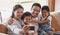 Selfies with the whole fam. an affectionate young family of four taking selfies on the sofa at home.