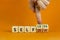 Selfish or selfless symbol. Businessman turns cubes and changes the word `selfish` to `selfless`. Beautiful orange background,