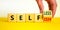 Selfish or selfless symbol. Businessman turns cubes and changes the word `selfish` to `selfless`. Beautiful white background,