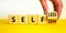 Selfish or selfless symbol. Businessman turns cubes and changes the word `selfish` to `selfless`. Beautiful white background,