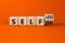 Selfish or selfless symbol. Turned cubes and changed the word `selfish` to `selfless`. Beautiful orange background, copy space
