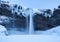 Seljalandsfoss waterfall, Iceland. Icelandic winter landscape.  High waterfall and rocks. Snow and ice. Powerful stream of water f