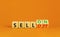 Sell on or off symbol. Businessman turns wooden cubes and changes word Sell off to Sell on. Beautiful orange table orange