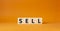Sell symbol. Concept word Sell on wooden cubes. Beautiful orange background. Business and Sell concept. Copy space