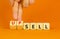 Sell or upsell symbol. Concept word Sell Upsell on wooden cubes. Businessman hand. Beautiful orange table orange background.