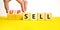 Sell or upsell symbol. Concept word Sell Upsell on wooden cubes. Businessman hand. Beautiful yellow table white background.