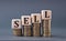 SELL - word on wooden cubes on coins on a gray background