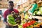 Seller arranging leafy vegetables on counter