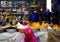 Seller of colorful spices with foreground woman with burqa in the souk of the city of Rissani in Morocco