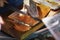 Seller cuts and sells salmon on wooden market board. Hands with knife close-up. Gastronomic fish produce, popular with